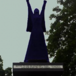 Silouette of a statue of a woman with raised arms